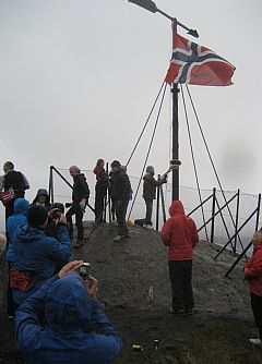 Jan O. Larsen heiste flagget 17. mai  2012 kl. 07:00. Også i år var det gråvær og dessuten pøsende regn. Ikke dårlig med 53 morgenfugler. Foto: K. L.